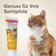 Eine Nahaufnahme einer Katze, die sich die Lippen leckt, neben einer Tube Beaphar Hühnerpaste, beschriftet mit "Genuss für Ihre Samtpfote" und Nährwertangaben.