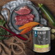 Dose LIEBESGUT Hundefutter (Ziege) neben rohem rotem Fleisch, Süßkartoffelscheiben, Zucchini und Blattgrün auf einer Holzoberfläche.