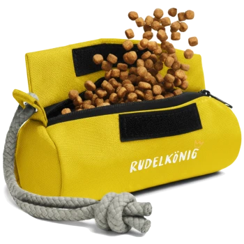 Ein leuchtend gelber Haustierfutterbeutel mit einem grauen Seilgriff, der Futter aus seinen offenen Reißverschlüssen auskippt, beschriftet mit "RUDELKÖNIG."