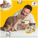 Katze frisst aus einer von einer Person gehaltenen DOGS'n TIGER-Schale; Produktbecher und Box vor gelbem Hintergrund, „Made in Germany“-Siegel.