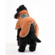 Schwarzer Hund trägt eine orangefarbene Fleecejacke mit einer blauen Tasche, von hinten auf weißem Hintergrund gesehen.