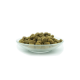 Eine Glasschüssel gefüllt mit kleinen, runden, braunen Haustierfutterpellets, vor einem weißen Hintergrund.