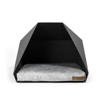 Ein modernes, graues Haustierbett mit einer dreieckigen Filzstruktur und einem weichen grauen Kissen im Inneren, mit einem kleinen braunen Etikett an der Seite.