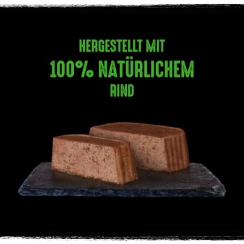 Karma dla zwierząt na powierzchni łupka z dwoma plastrami mięsa i zielonym tekstem "WYPRODUKOWANE Z 100% NATURALNEJ WOŁOWINY."