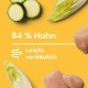 Zutaten für Haustierfutter: geschnittene Zucchini, Salat und rohes Huhn auf einem gelben Hintergrund. Text: "84% Huhn" und "Leicht verdaulich."