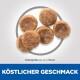 Bild von sechs runden Haustierfutterpellets, etwa 4 x 7,5 mm groß, mit dem Text "Köstlicher Geschmack" am unteren Rand.