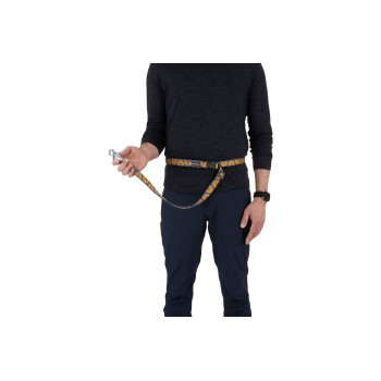 Eine Person trägt ein dunkles Langarmshirt und eine marineblaue Hose, hält eine bunte Hundeleine, die an einem Gürtel befestigt ist, bereit für einen Spaziergang.