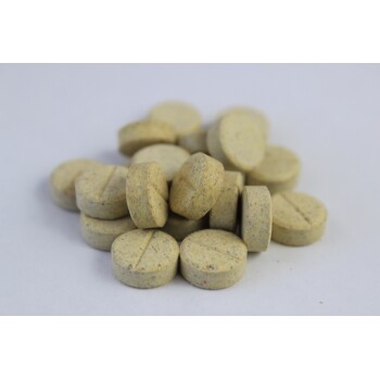 Ein Haufen runder, hellbrauner Haustier-Vitamine oder -Nahrungsergänzungsmittel mit einer strukturierten Oberfläche, von denen einige eine Teilungslinie oben zeigen.