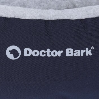 Logo von 'Doctor Bark' auf einem dunklen Stoffhaustierbett mit einer weichen grauen Innenauskleidung.