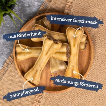 Premium Hundekauknocken, die auf einer Holzoberfläche gestapelt sind, mit einem dekorativen grünen Gras-Hintergrund.