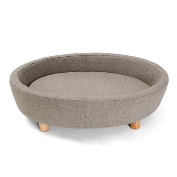 Ein runder, grauer Haustierbett mit einem weichen Stoffbezug und Holzbeinen, entworfen für Komfort und Stil.