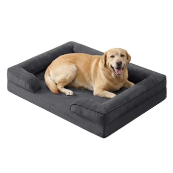 Goldener Labrador liegt auf einem dunkelgrauen, rechteckigen Hundebett mit erhöhten Seiten und lächelt.