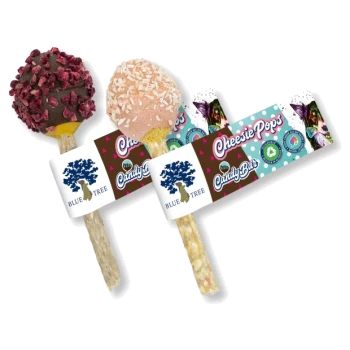 Dwie kolorowe przysmaki dla zwierząt, 'Cheesie Pops', wyeksponowane na patykach. Jeden pokryty ciemną czekoladą i kawałkami malin, drugi w różowym kokosie.