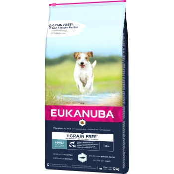 Ein glücklicher Hund läuft durch Wasser auf einem grasbewachsenen Feld, neben einem Sack Eukanuba getreidefreiem Hundefutter mit der Aufschrift "Low Allergen Recipe."