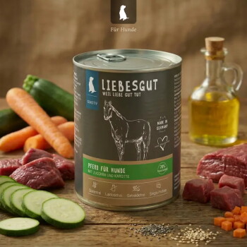 Dose LIEBESGUT Hundefutter mit Aufschrift „Pferd für Hunde“ mit Zucchini und Karotte, umgeben von geschnittener Zucchini, Karotten, rohem Fleisch und einer Flasche Öl