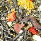 Eine Nahaufnahme einer bunten Mischung aus getrockneten Kräutern und Blumen, mit roten und gelben Blütenblättern, grünen Blättern und Zweigen, ideal für die Haustiernahrung.
