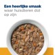 Een kom huisdierenvoer met stukjes vlees en groenten, met tekst die zegt 'Een heerlijke smaak waar huisdieren dol op zijn.'