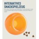 Interaktives Snackspielzeug in leuchtendem Orange, mit kleinen, dreieckigen Leckerlis daneben; Text beschreibt die Verwendung für Hunde.