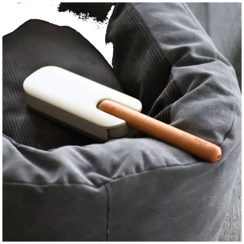 Modernes Haustierpflegewerkzeug mit einem beigen Griff und einem Holzgriff, entworfen für eine einfache Anwendung.