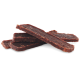 Ein Stapel von zähen, dunkelbraunen Haustierleckereien, die wie Jerky-Streifen aussehen, auf einem weißen Hintergrund angeordnet.