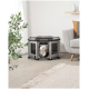 Ein kleiner weißer Hund schaut aus einem grauen Haustierspielbereich mit Netzseiten heraus, der sich in einem gemütlichen Wohnzimmer mit einem hellen Teppich und einem Sofa befindet.