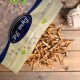 Getrocknete Fischleckerlis für Haustiere, die aus einer wiederverschließbaren Tüte mit der Aufschrift "Premium Quality" auf einer Holzoberfläche fallen.