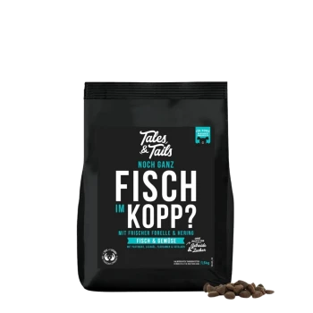 Schwarze Tales & Tails Tierfuttertüte mit der Aufschrift ‚FISCH IM KOPP?‘ sowie ‚Mit frischer Forelle & Hering‘ und einem Haufen Trockenfutter.
