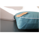 Teal hexagon-patterned pet bed cushion with white piping and a tan hang tag showing a black logo.