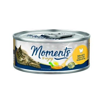 Cat food can with a gray and blue design, featuring the text "Moments to enjoy," and "Huhn mit Ei" (Chicken with Egg) in yellow.