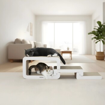 Zwei Katzen ruhen auf einem modernen weißen Katzenmöbelstück mit dem Markennamen „PetRhein“ in einem hellen Wohnzimmer.