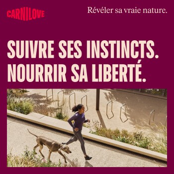 Femme courant avec un grand chien en laisse sur un sentier ; fond publicitaire bordeaux portant l'inscription « SUIVRE SES INSTINCTS. NOURRIR SA LIBERTÉ. »
