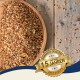 Eine Holzschüssel mit verschiedenen Samen und Körnern, einige verstreut, mit einem Abzeichen, das "Beste Qualität" und "10 Jahre" auf Deutsch sagt.