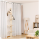 Zwei Katzen, eine flauschige und cremefarbene, die andere grau und weiß, sitzen auf einem hohen Katzenbaum mit mehreren Plattformen in einem modernen Wohnzimmer.