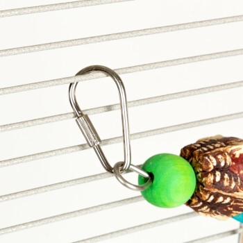 Eine Nahaufnahme eines Metallclips, der an bunten Holzperlen und einem Stück Naturholz befestigt ist, das an einem Drahtkäfig hängt.