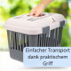 Beige-graue Transportbox mit belüfteten Seiten, eine Hand greift den oberen Griff; Einblendungstext 'Einfacher Transport dank praktischem Griff'