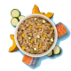 Schüssel mit gemischtem Tierfutter mit Stücken von Zucchini, Kürbis und Lachs auf blauem Hintergrund.