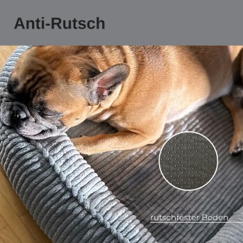 Ein schlafender Französischer Bulldogge auf einem weichen, grauen Haustierbett mit geripptem Design, mit einem kreisförmigen Ausschnitt, der die rutschfeste Unterseite zeigt.