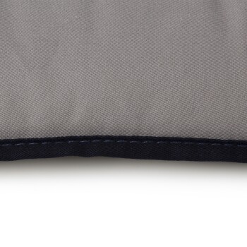 Ecke eines grauen Haustierbettes mit dunkelblauen Nähten, das aus einem weichen, strukturierten Stoff besteht.