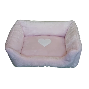 Un lit pour animaux doux et rose avec des côtés en peluche et un design de cœur blanc sur le coussin central, idéal pour les petits animaux de compagnie.