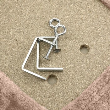 Metallbaugruppen, einschließlich einer gebogenen L-förmigen Halterung und Schrauben auf einer strukturierten Oberfläche, mit einem weichen rosa Stoffrand.