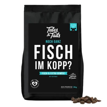 Schwarze Tüte Tales & Tails Hundefutter mit der Aufschrift „Fisch im Kopp? Fisch & Extra Gemüse“ mit Kibble-Stücken daneben.