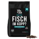 Schwarze Tüte Tales & Tails Hundefutter mit der Aufschrift „Fisch im Kopp? Fisch & Extra Gemüse“ mit Kibble-Stücken daneben.