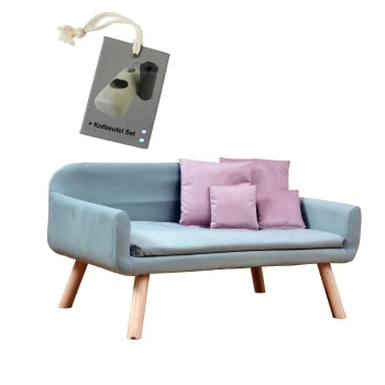 Hundesofa Chicago mit Gratis-Beigabe hellblau Ein hellblaues Haustiersofa mit Holzbeinen, verziert mit rosa Kissen, begleitet von einem Etikett, das ein Set mit Hundekotbeuteln zeigt.