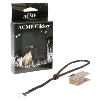ACME Clicker Hundetrainingspfeife mit geflochtenem Lederband, gezeigt mit Verpackung, die einen Hund und Grasdesign zeigt.