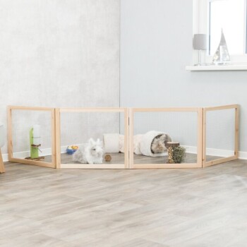 Ein hölzernes Haustierspielgehege mit einem flauschigen weißen Kaninchen und einem grauen Kaninchen, die darin ruhen, umgeben von Spielzeug und einer gemütlichen Decke.