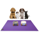 Eine Gruppe von drei Hunden und einer Katze sitzt auf einer lila Matte, mit zwei Futternäpfen davor. Die Näpfe sind grau und weiß und werden von Holzständern gestützt.