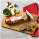 Eine Verpackung von 'Fleischeslust Rindermenü' Haustierfutter auf einem Holzschneidebrett, mit geschnittenen Portionen, frischem Gemüse und einem Messer.