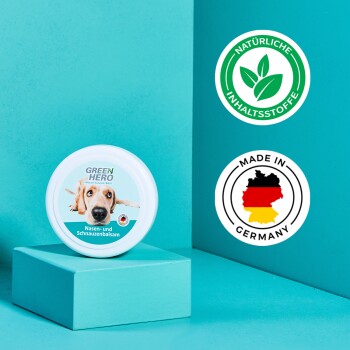Ein runder weißer Behälter mit der Aufschrift "GREEN HERBS Nasen- und Schnauzenbalsam" auf Türkis, mit den Siegeln "NATÜRLICHE INHALTSSTOFFE" und "MADE IN GERMANY."