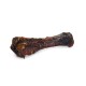 Duża, mięsista kość dla psa z ciemną, przypaloną powierzchnią, prezentująca bogatą, soczystą teksturę idealną do żucia.