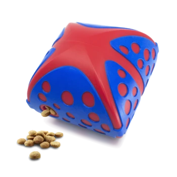Jouet distributeur de friandises pour animaux en forme d'étoile rouge et bleue avec plusieurs trous et des croquettes qui débordent d'une ouverture.